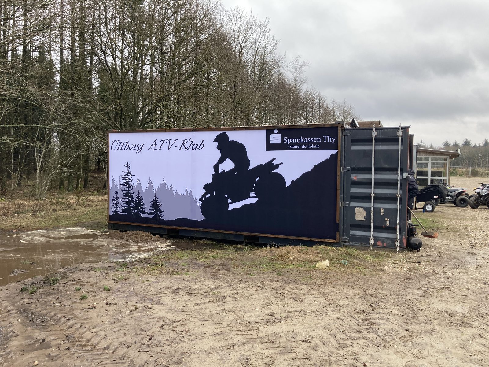 Klubbens container med Ulfborg ATV-Klub silhuet-banner sponsoreret af Sparekassen Thy